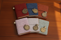 Mini lace-embossed traveller's notebooks with bronze pocket watch charms on a Regency-style writing desk