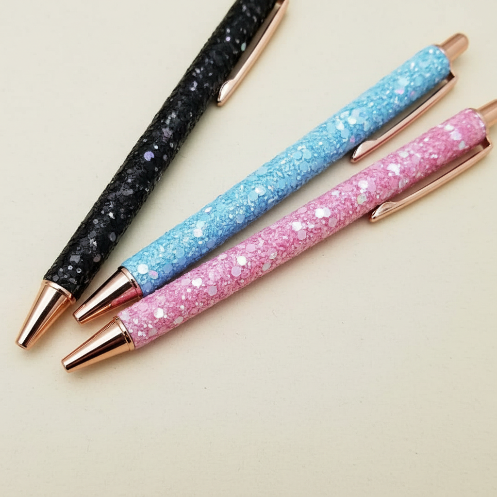 Sparkle ballpoint pens zoomed in on dark cream background showing glitter effect