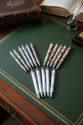 Floral patterned ballpoint pens arranged on a Regency mahogany writing desk