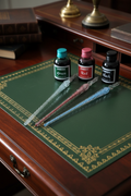 Glass fountain pens and Karkos ink bottles on a Regency mahogany writing desk